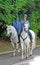Policeman and police woman ride white horses