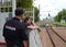 A policeman talks to a drunken citizen on a railway platform.