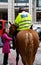 Policeman talks to women on street.