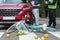 Policeman writes a ticket standing in front of a red car that hit a cyclist