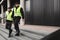 Policemen in vests looking around carefully during patrol in the city center