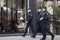 Policewoman and policemen on duty, wearing surgical face masks while walking city street