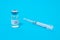 Polio vaccine and syringe on a blue background. Vaccination and prevention poliomyelitis. Infantile paralysis