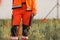 Polish ambulance worker standing in medical orange uniform with reflective elements and holds a folder with documents.