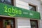 Polish grocery store sign ZABKA cafe. Green signboard supermarket. House building facade. Street shop. Warsaw, Poland -