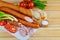 Polish kielbasa with vegetables and bread on wooden background