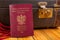 Polish passport and travel suitcase on a wooden table. Accessories for the traveler before the international trip