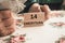 Polish pensioner holds money and wooden blocks with the inscription 14 pension in Polish. Social concept. Additional 13th and