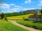 Polish rural road, yellow rapeseed, canola or colza field and horse farm in the summer, landscape. Lublin, Stasin