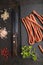 Polish smoked sausage kabanos on a slate cutting board on black concrete background. Top view, close up