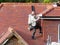 Polish workmen fitting gutter to fascia board of new house roof dormer