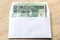 Polish zloty currency hundred notes in white envelop on table. C