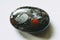 Polished blood jasper gemstone on a white background