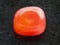 polished carnelian gem on dark background