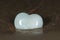 Polished cream white carved Onyx Heart on wet sand on the beach at sunrise in front of the lake. Love, Romance and Friendship