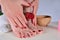 Polished Elegance: Female Feet and Hand with Dark Red Nails in Salon