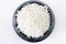 Polished long rice basmati in a stone bowl top view isolated