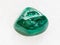 polished Malachite gemstone on white marble