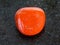 polished red coral gemstone on dark background