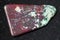 polished red Cuprite and green Chrysocolla on dark