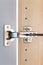 Polished stainless door hinge on a opened cabinet door for interior design. Heavy-duty hinges are designed to provide support and