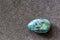 Polished tumbled chrysocolla stone on a black background