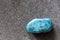 Polished tumbled chrysocolla stone on a black background