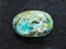 polished turquoise gemstone on dark background