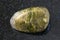 polished unakite gem stone on dark background