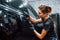 Polishing surface of vehicle. Modern black automobile get cleaned by woman inside of car wash station