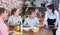 Polite professional waitress serving dishes to family