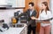 Polite salesgirl helping young man in choice of mixer tap in kitchen furniture salon