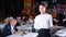 Polite waitress with serving tray warmly welcoming in restaurant