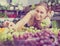 Polite young female seller holding bunch of grapes on market