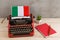 Political, news and education concept - red typewriter, flag of the Italy, notebook