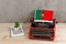 Political, news and education concept - red vintage typewriter, flag of the Portugal, pencil, notepads