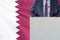 Political personality standing on the stage for conference on Qatar flag background. Male speaker in Qatar
