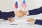 Political representatives of American and Russian states shake hands before negotiations begin.