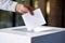 A political statement: A hand inserts a ballot into the box