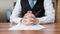 Politician with clapsed hands sitting behind desk