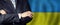 Politician crossed arms of on Ukraine flag background