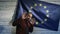 Politician scared standing near the flag of the European Union