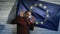 Politician scared standing near the flag of the European Union