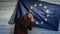 Politician scared standing near the flag of the European Union