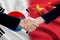 Politicians handshake with chinese and south korean flags