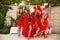 Polka dot birthday party. Group of female friends enjoying and laughing. Women in dresses having fun by Photo zone from red and