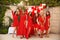 Polka dot birthday party. Group of female friends enjoying and laughing. Women in dresses having fun by Photo zone from red and