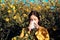 Pollen allergy concept. Young woman is going to sneeze. Closeup portrait of sneezing girl at yellow flowers background