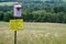 Pollinator Field Sign and Birdhouse With Flowers and Meadow in Background