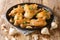 Pollo al Ajillo is a Spanish version of garlic chicken cooked with a garlic and white wine close-up on a plate. Horizontal